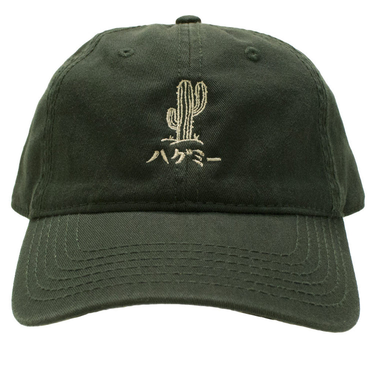 Green dad hat with an embroidered cactus that reads 'hug me' in Japanese on the front.