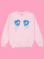 A pastel pink sweatshirt with mahou shoujo anime eyes on it.