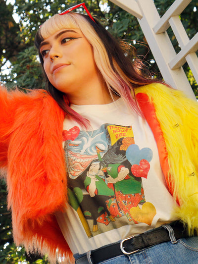A model wearing a funny beige ukiyo-e samurai and yokai t-shirt.