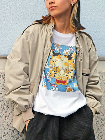 A model wearing a white t-shirt with a trippy cat design on it.