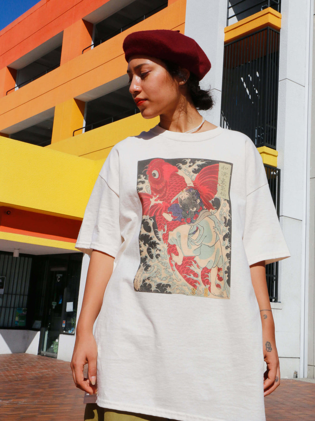 A model wearing a beige t-shirt with a Japanese koi fish on it.