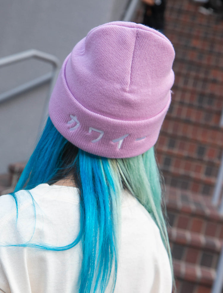 Model wearing a lavender beanie that reads kawaii meaning cute in Japanese.