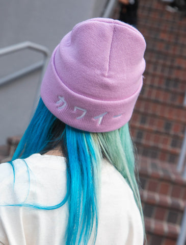 Model wearing a lavender beanie that reads kawaii meaning cute in Japanese.