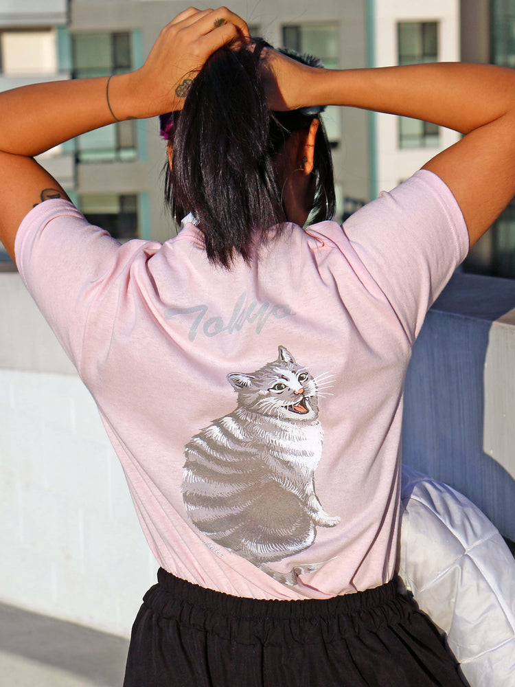 Back of a pink t-shirt with an illustration of a cat and the words 'Tokyo' on it.