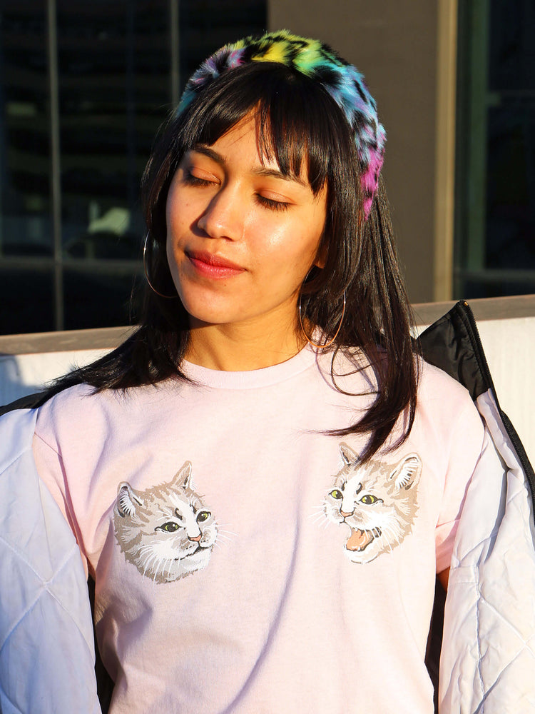 Front of a pink t-shirt with an illustration of two cats on the chest.
