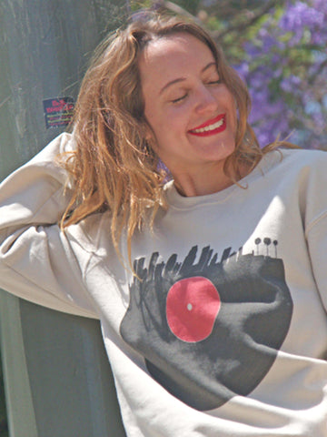 Beige sweater with a vinyl record shaped like the city of LA on it.