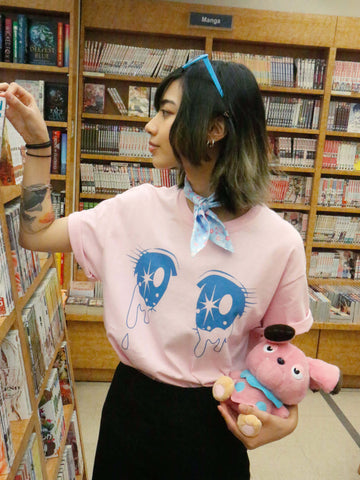 Model wearing a kawaii pink t-shirt with sparkling magical girl eyes on it.