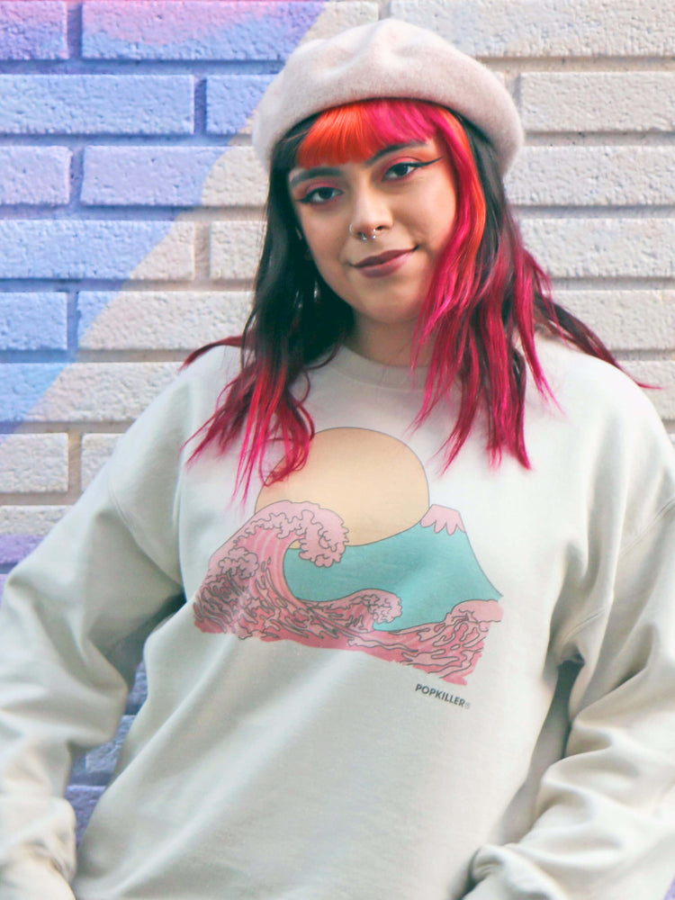 Model wearing a beige sweater with Mt. Fuji and the Great Wave printed on it.