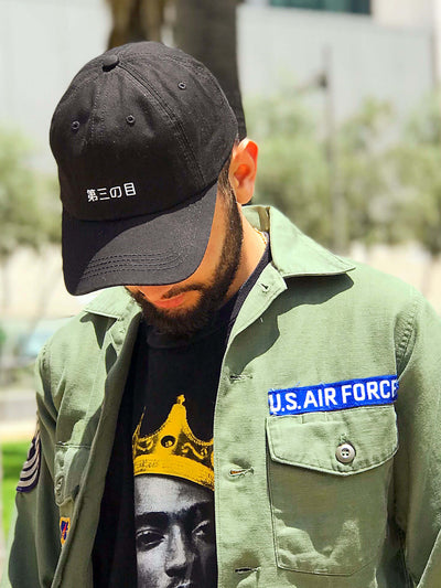 A black dad hat with 'third eye' in Japanese printed on the front.