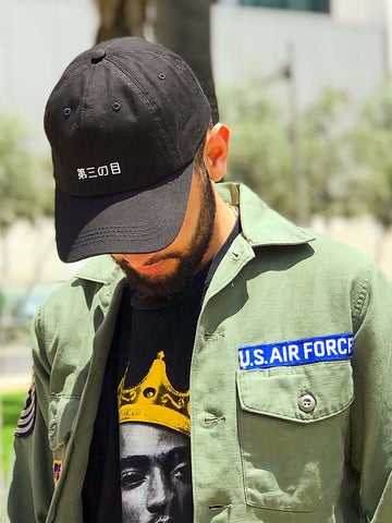 A black dad hat with 'third eye' in Japanese printed on the front.