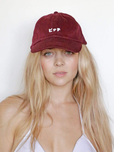 Maroon polo cap that reads 'bitch' in Japanese.