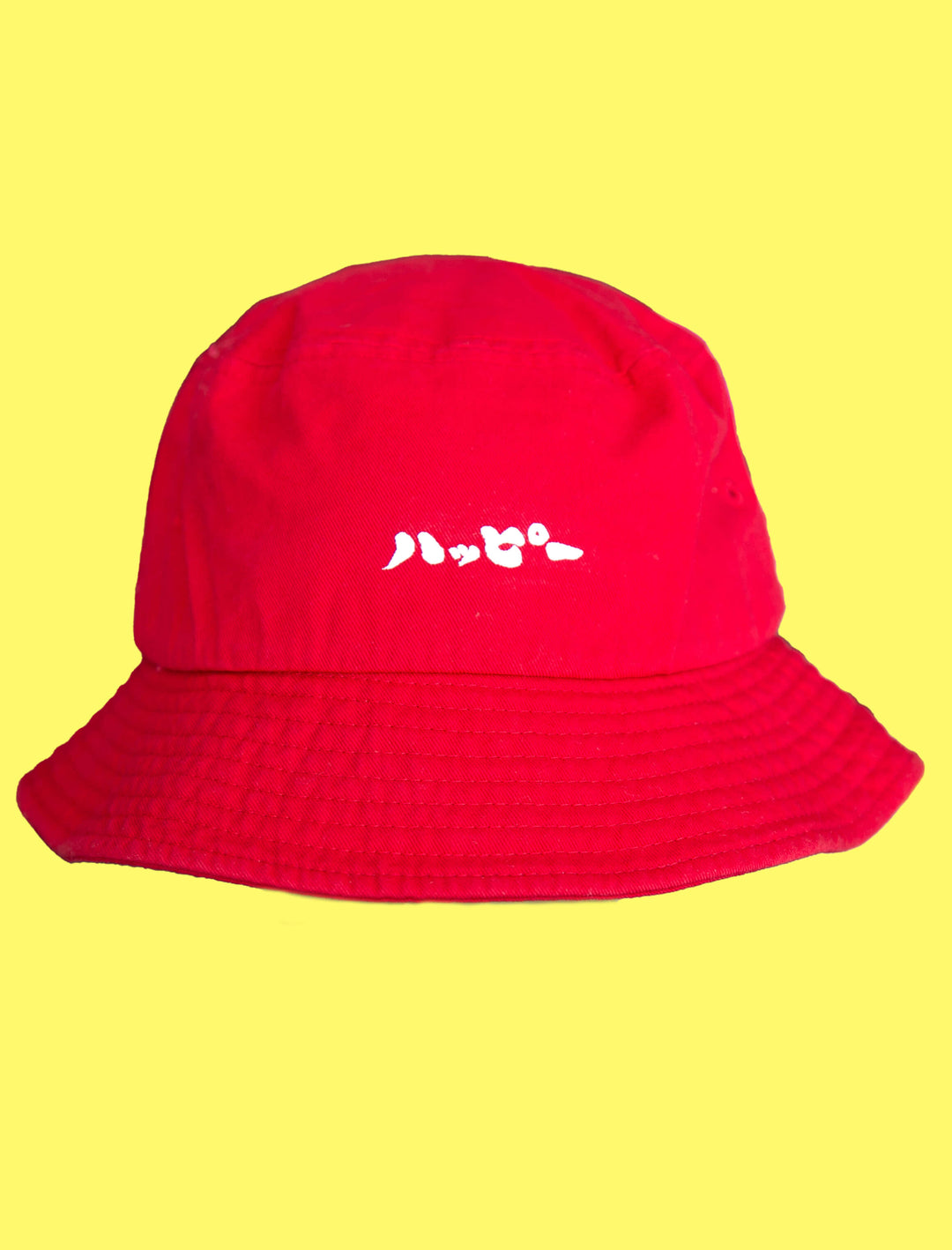 Red bucket hat with the word happy in Japanese katakana on it.