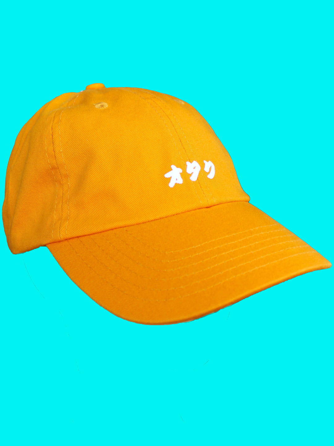 Mustard baseball cap with the word otaku printed on the front.