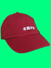 A maroon polo cap with the words 'Bad Girl' spelled out in katakana on it.
