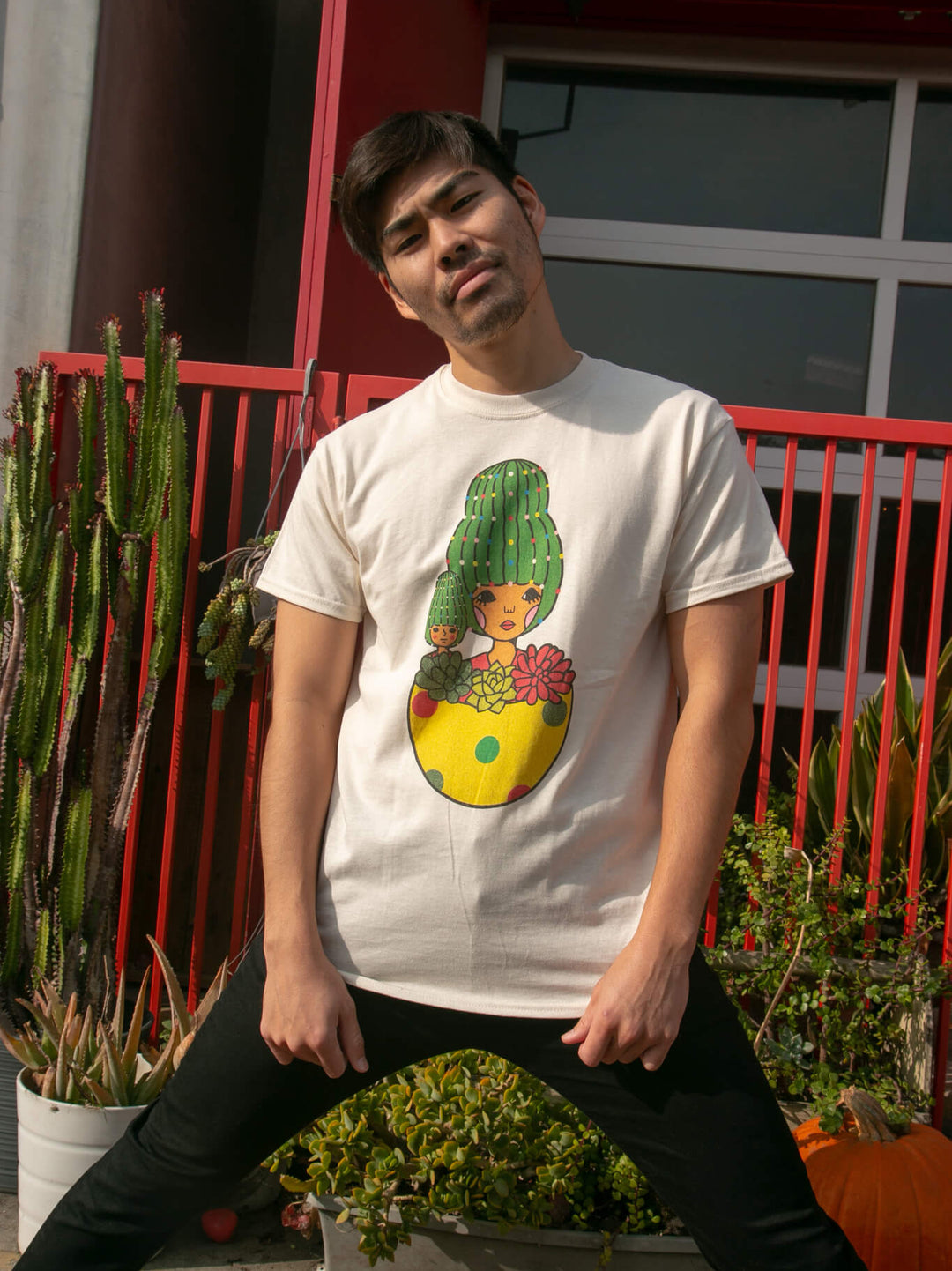Model wearing holiday season graphic tee with cactus pot designed by sunae artist Naoshi.