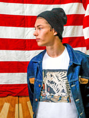A model wearing a Japanese graphic t-shirt with a denim jacket over it.